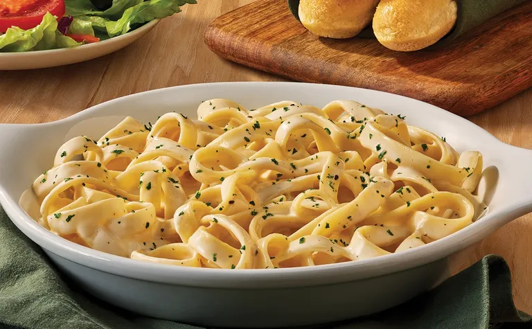 Fettuccine Alfredo — Our signature alfredo made fresh in-house every morning, served over fettuccine.