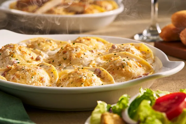 Ravioli Carbonara — Cheese ravioli baked in a creamy sauce with bacon, topped with a blend of Italian cheeses.