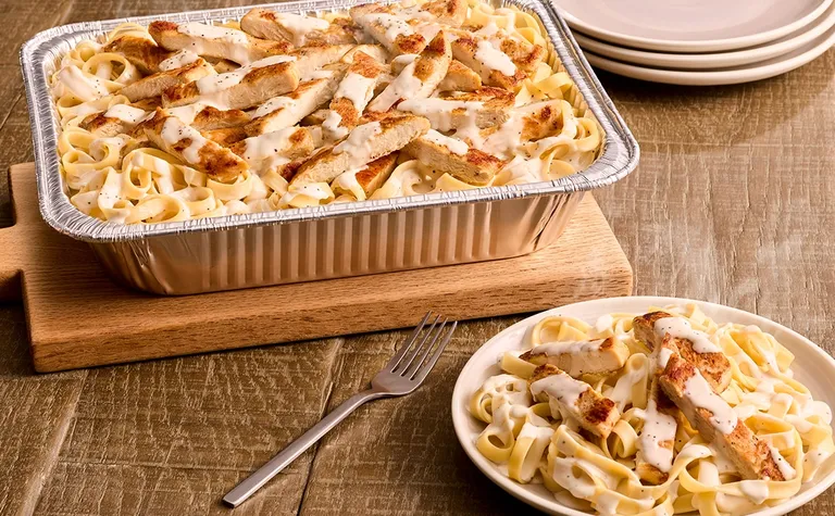 Chicken Alfredo (Serves 4 - 6) — Includes: A pan of sliced grilled chicken and fettuccine pasta with our signature homemade…
