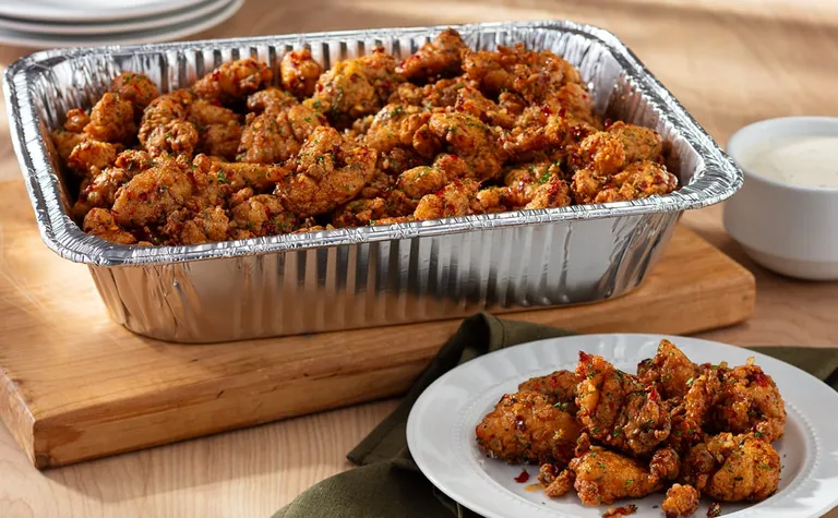 Calabrian Hot Honey Chicken Bites (Serves 4 - 6) — Crispy chicken bites tossed in a sweet and spicy Calabrian hot honey…
