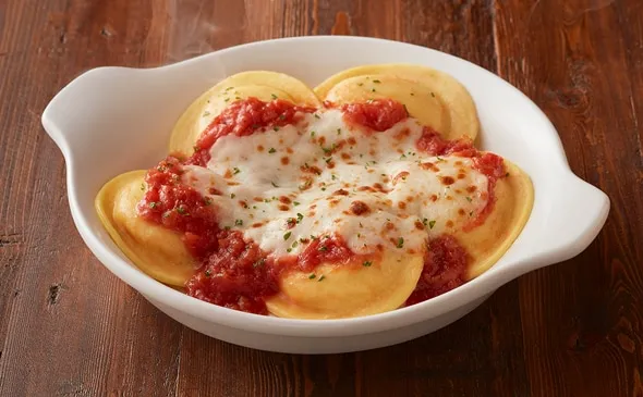 Cheese Ravioli — Topped with melted mozzarella and your choice of homemade marinara (V) or meat sauce.**