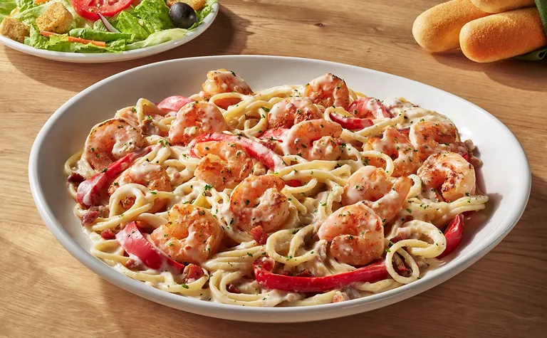 Shrimp Carbonara — Shrimp sautéed in a creamy sauce with bacon and roasted red peppers, over spaghetti.