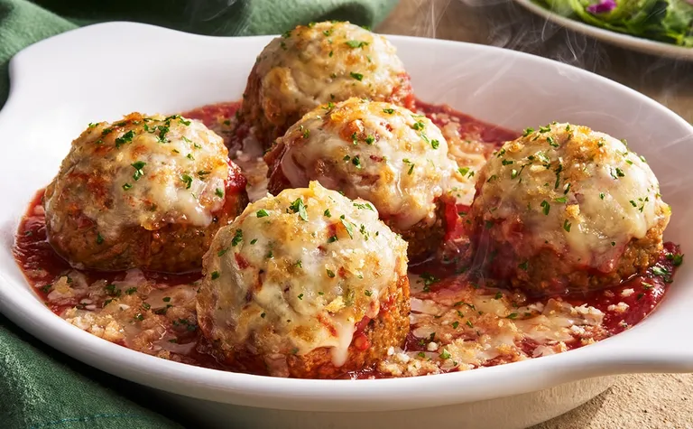 Meatballs Parmigiana — Five hearty meatballs baked in homemade marinara, topped with melted Italian cheeses and toasted…