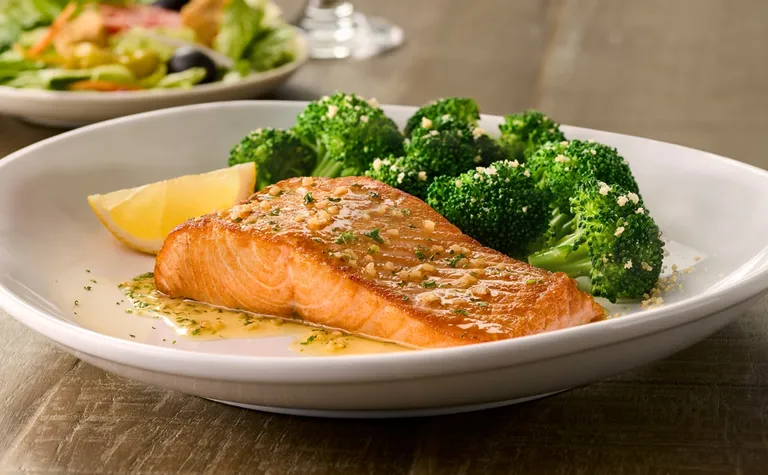 Herb-Grilled Salmon — Filet grilled to perfection and topped with garlic herb butter. Served with parmesan garlic broccoli.
