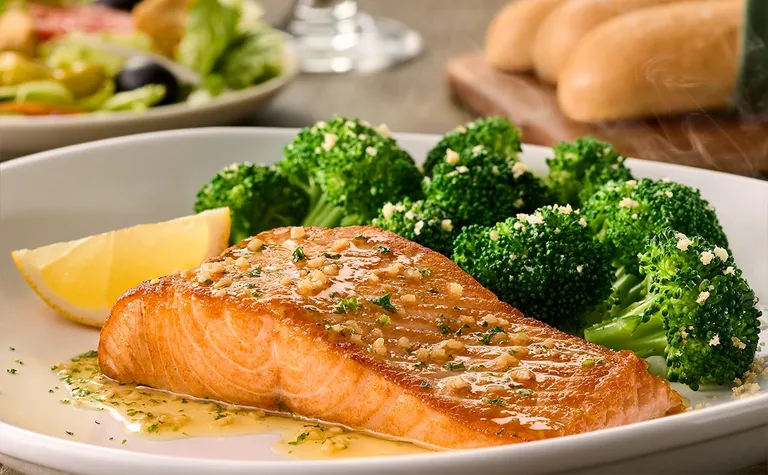 Herb-Grilled Salmon — Taste the Mediterranean in our salmon filet grilled to perfection and topped with garlic herb butter…