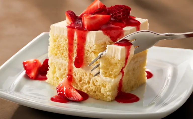 Strawberry Cream Cake — Vanilla sponge cake layered with sweet vanilla cream and topped with fresh strawberries.