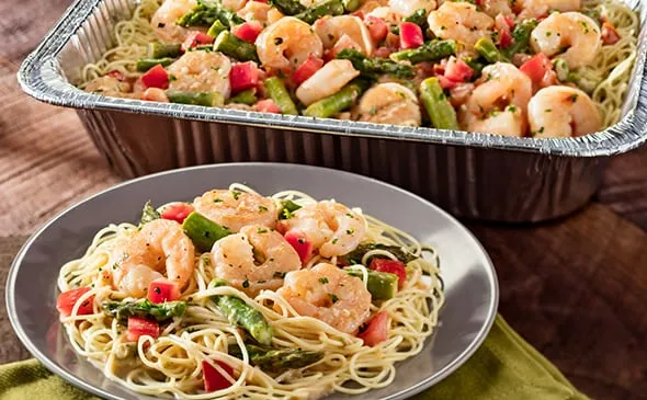 Shrimp Scampi (Serves 4 - 6) — Includes: A pan of shrimp sautéed in a garlic sauce, tossed with asparagus, tomatoes, and…