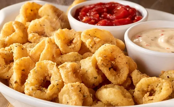 Calamari — Order tender, lightly breaded and fried calamari as an appetizer. Dip each bite in marinara sauce or spicy ranch…